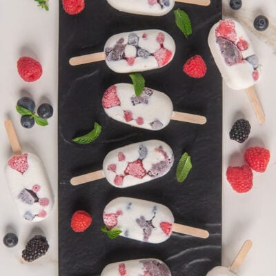 Mini gelati allo yogurt e frutti di bosco con lamponi, mirtilli e more visibili nell'impasto