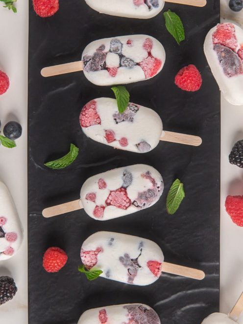 Mini gelati allo yogurt e frutti di bosco con lamponi, mirtilli e more visibili nell'impasto