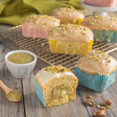 Mini plumcake al pistacchio glassati con granella, uno tagliato a metà rivela il cuore di crema