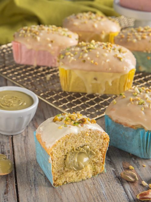 Mini plumcake al pistacchio glassati con granella, uno tagliato a metà rivela il cuore di crema