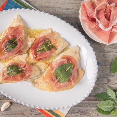 Saltimbocca di orata con prosciutto crudo e foglie di salvia fermate da stuzzicadenti, nappati di burro fuso