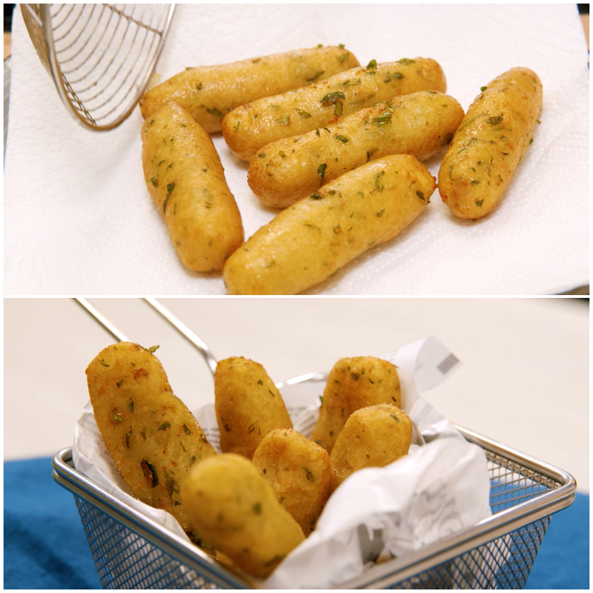 Cazzilli fritti scolati su carta assorbente, poi trasferiti nel cestino da frittura con le pinze