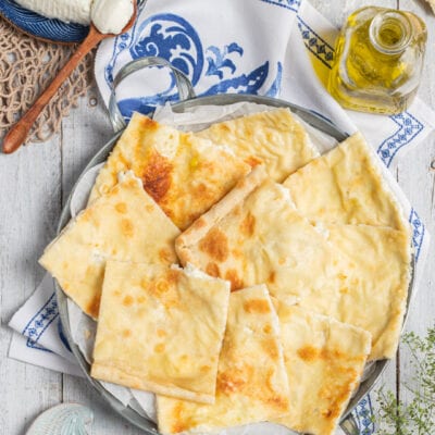 Focaccia di Recco tagliata a pezzi irregolari con ripieno di formaggio cremoso e superficie dorata