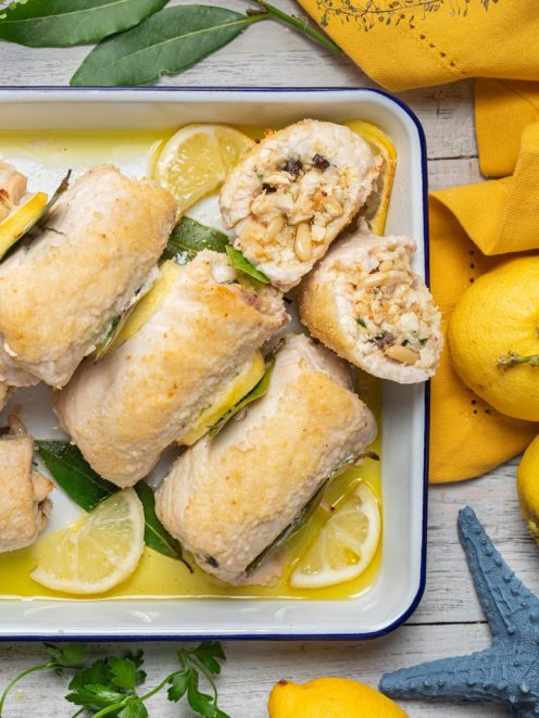 Involtini di spada alla messinese con ripieno di pinoli e uvetta, serviti con fette di limone e foglie di alloro
