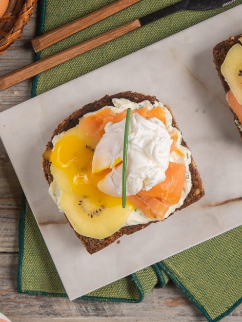 Crostone con kiwi, salmone affumicato e uovo pochè su pane integrale con crema al formaggio