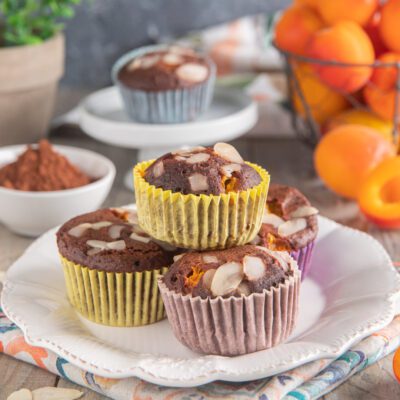 Muffin al cacao con albicocche e mandorle a scaglie, impilati su un piatto