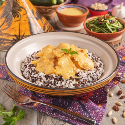 Curry di cernia servito su riso venere e basmati con foglia di menta fresca