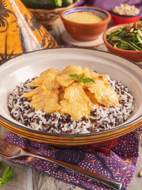 Curry di cernia servito su riso venere e basmati con foglia di menta fresca