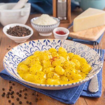 Gnocchi con crema cacio e pepe allo zafferano conditi con pepe nero macinato e pistilli