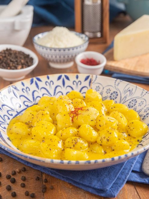 Gnocchi con crema cacio e pepe allo zafferano conditi con pepe nero macinato e pistilli