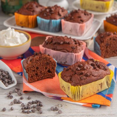 Mini plumcake al cacao e cioccolato in stampini colorati, con gocce di cioccolato e uno tagliato a meta