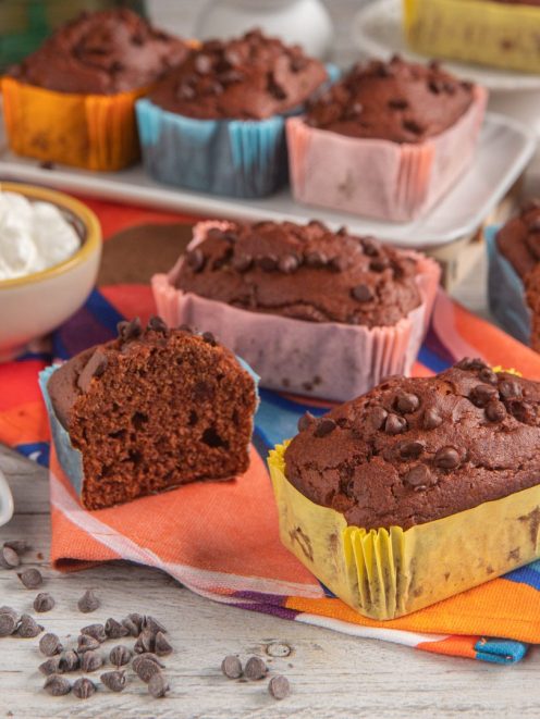 Mini plumcake al cacao e cioccolato in stampini colorati, con gocce di cioccolato e uno tagliato a meta