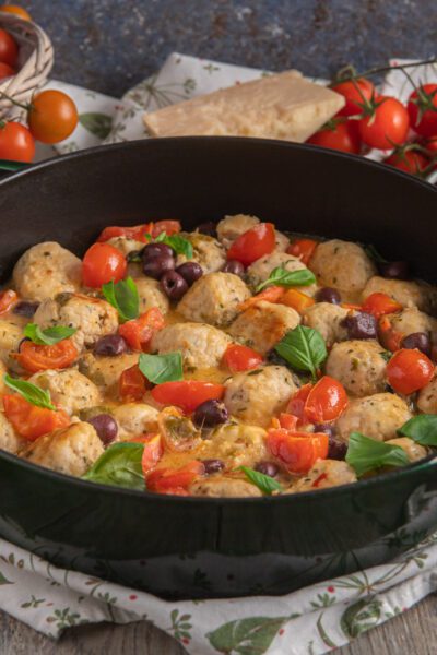 Polpette di tacchino con pomodorini, olive nere e basilico fresco in padella
