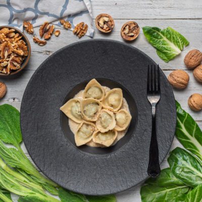 Pansoti con salsa di noci cremosa, serviti in porzione generosa dall'aspetto rustico