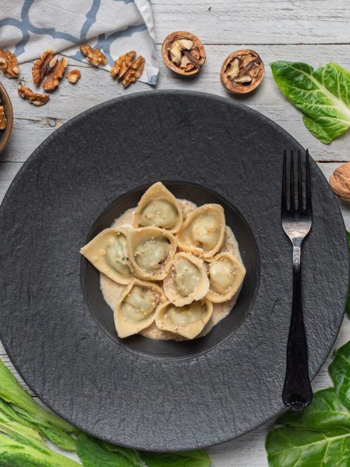 Pansoti con salsa di noci cremosa, serviti in porzione generosa dall'aspetto rustico