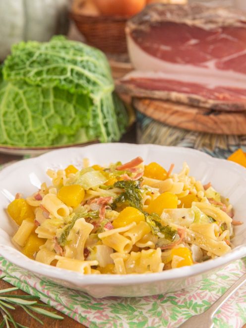 Pasta alla zucca con verza e speck, condita con dadini di zucca gialla e foglie di cavolo stufate