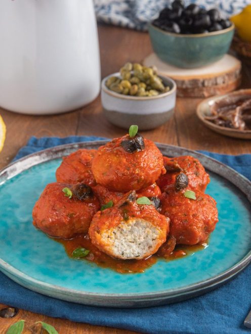 Polpette di branzino alla mediterranea in sugo di pomodoro con olive nere e origano fresco