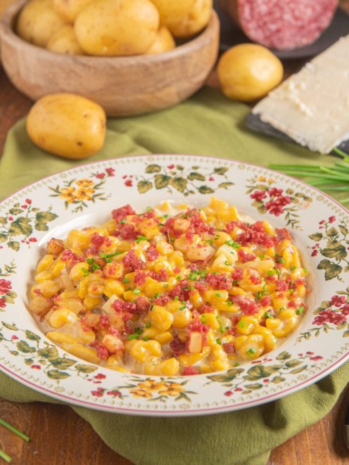 Spatzle alla zucca con gorgonzola, patate e briciole di salsiccia guarnite con erba cipollina