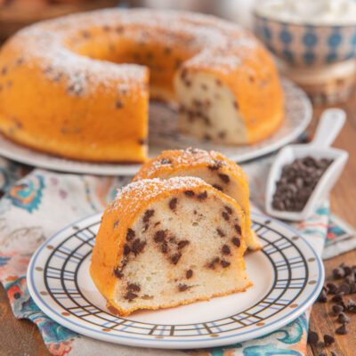 Ciambella di albumi, yogurt e gocce di cioccolato affettata e cosparsa di zucchero a velo
