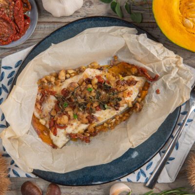 Orata al cartoccio aperta con zucca, pomodori secchi, erbe aromatiche e frutta secca