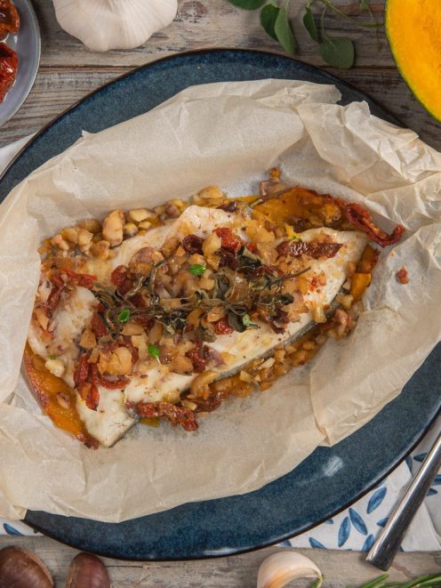 Orata al cartoccio aperta con zucca, pomodori secchi, erbe aromatiche e frutta secca