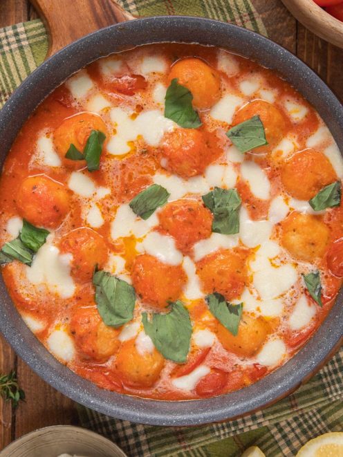 Polpette di baccalà in sugo di datterini con mozzarella filante e foglie di basilico