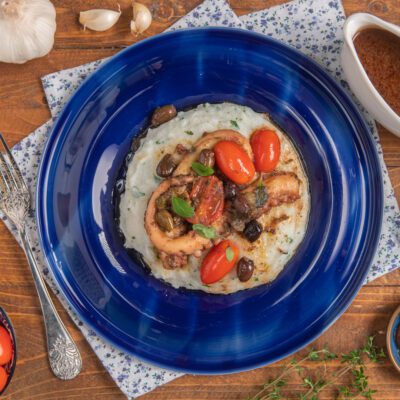 Polpo alla mediterranea su polentina alle erbe con pomodorini, olive e capperi