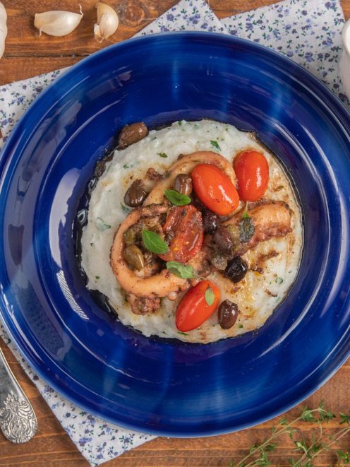 Polpo alla mediterranea su polentina alle erbe con pomodorini, olive e capperi