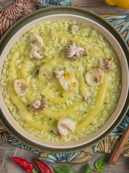 Risotto con crema di patate e seppioline mantecato al pesto, con vortice di salsa gialla