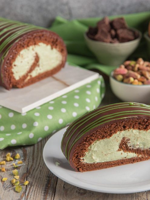 Rotolo al pistacchio con pan di spagna al cacao, crema verde e glassa striata servito a fette
