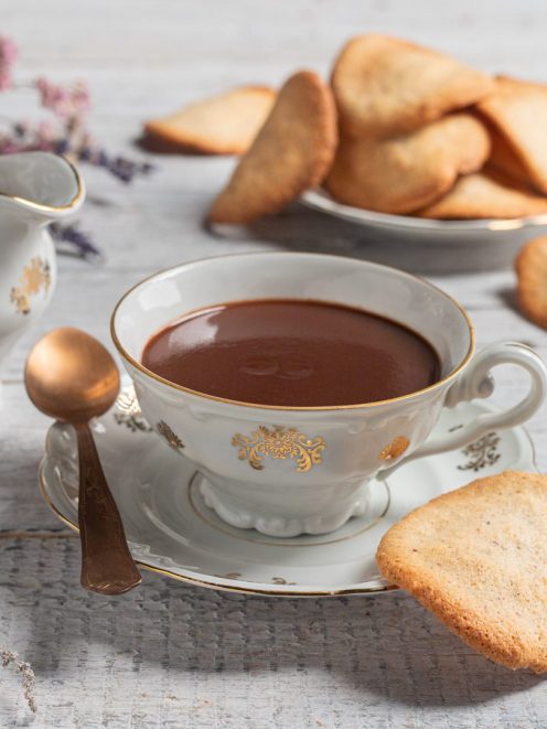 Tegole valdostane servite accanto a una tazza di crema di Cogne densa e lucida