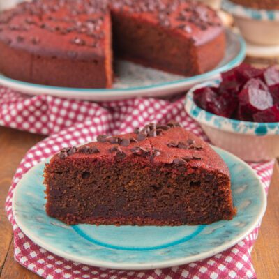 Torta alla barbabietola e cioccolato con gocce di cioccolato in superficie, servita a fetta
