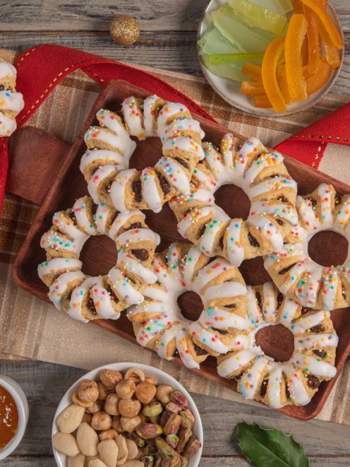 Bucellati siciliani glassati con glassa bianca e confettini colorati, ripieni di frutta secca