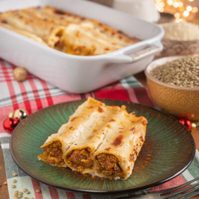 Cannelloni con ragù di cotechino gratinati, coperti di besciamella dorata, con il ripieno ben visibile