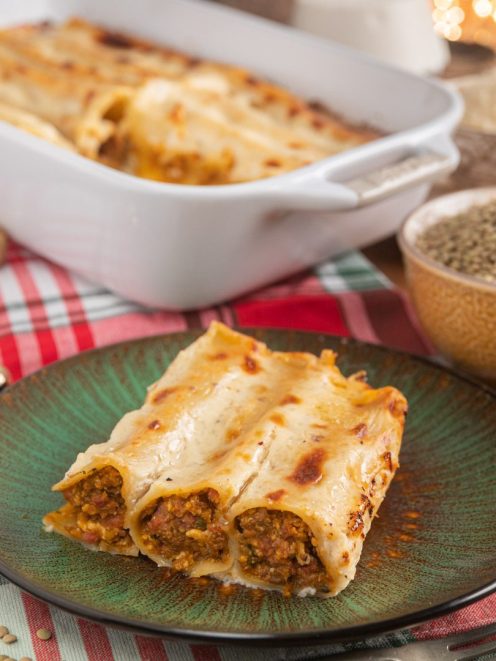 Cannelloni con ragù di cotechino gratinati, coperti di besciamella dorata, con il ripieno ben visibile