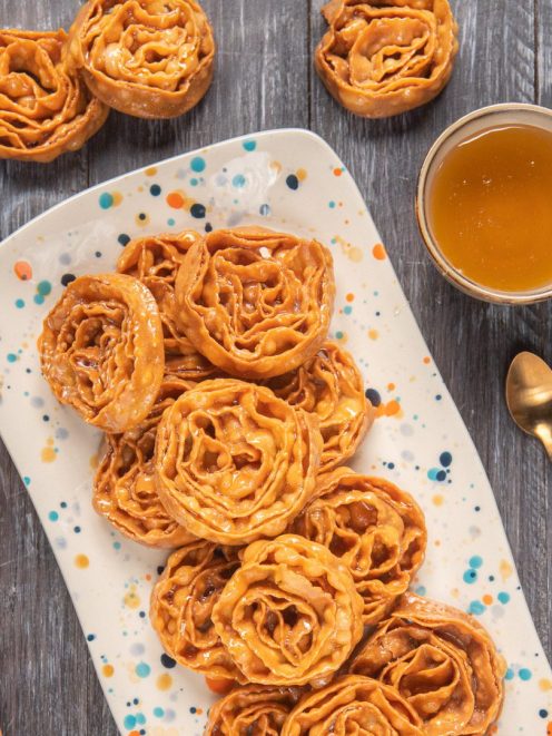 Cartellate fritte a forma di rosa glassate con miele ambrato, servite su vassoio