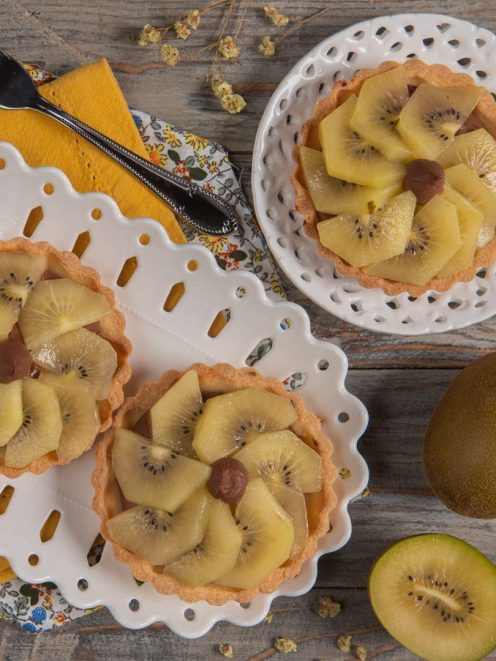 Crostatine alla crema e kiwi giallo disposte a ventaglio su pasta frolla dorata