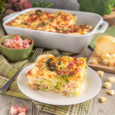 Lasagne con broccoli, provola e pancetta affumicata: una fetta mostra gli strati con besciamella gratinata