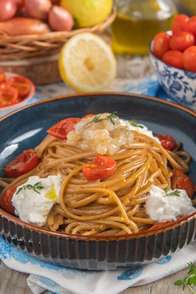 Linguine con crema di scampi, ciuffi di burrata e pomodorini confit guarniti con timo fresco