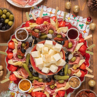 Pan Montrone con spiedini di salumi, olive, pomodorini e formaggi su vassoio natalizio