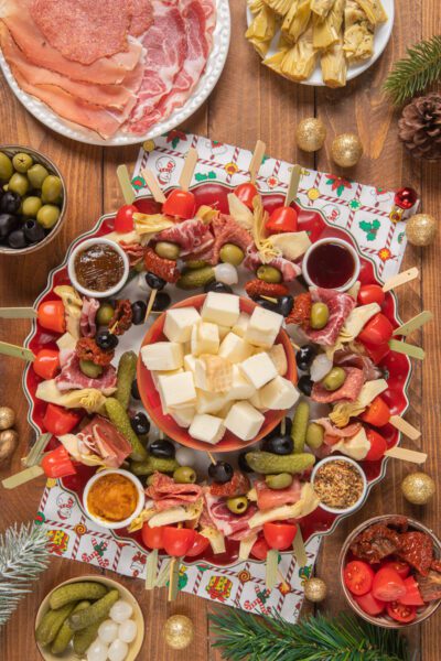 Pan Montrone con spiedini di salumi, olive, pomodorini e formaggi su vassoio natalizio