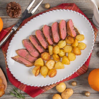 Petto d'anatra affettato al rosa servito con patate novelle rosolate