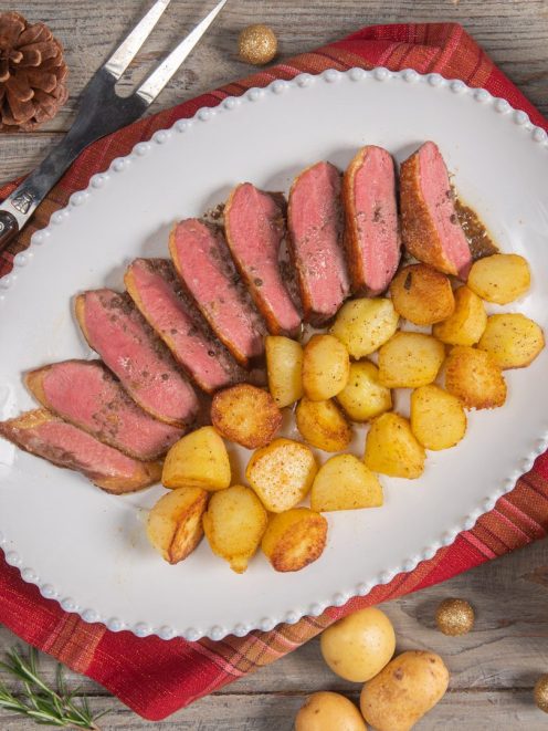 Petto d'anatra affettato al rosa servito con patate novelle rosolate