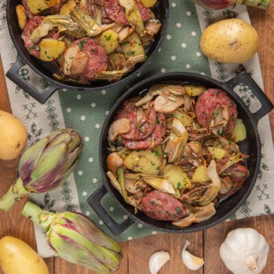 Rosticciata con zampone, carciofi e patate servita in padella di ferro