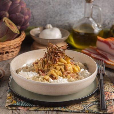 Spätzle con crema di carciofi, guanciale e burrata, guarniti con erbe croccanti e pomodori secchi