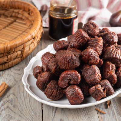 Turdilli fritti e glassati al miele, impilati con stecche di cannella intorno