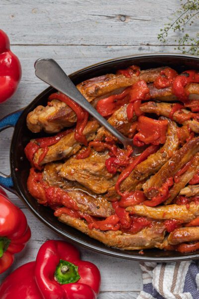 Costine di maiale ai peperoni rosolate in tegame con peperoni saltati e sugo denso