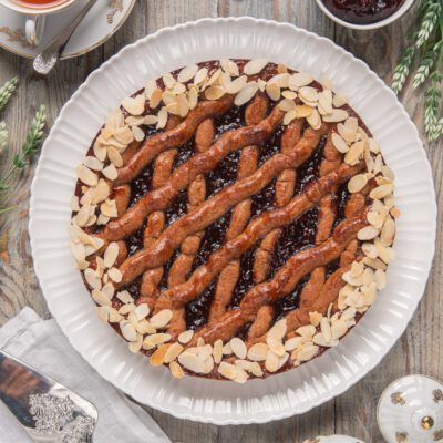 Linzer Torte con reticolo di pasta intrecciata, confettura di frutti rossi e mandorle a lamelle