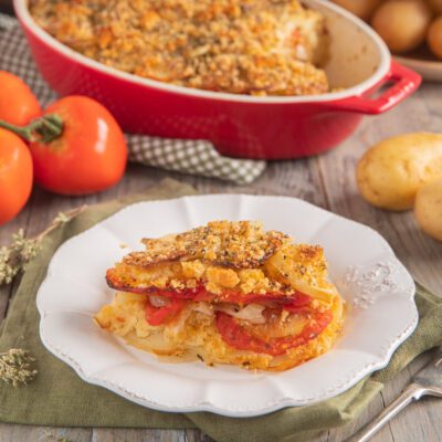 Patate raganate con strati di pomodoro e cipolla, gratinate con pangrattato croccante