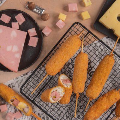 Stecchi alla petroniana fritti su stecco, uno spezzato rivela il ripieno di mortadella e formaggio
